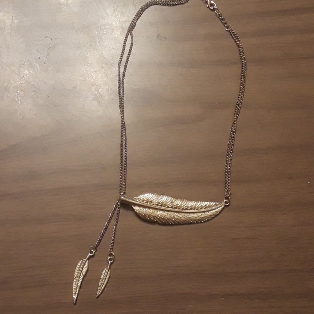 Gold metal feather necklace.